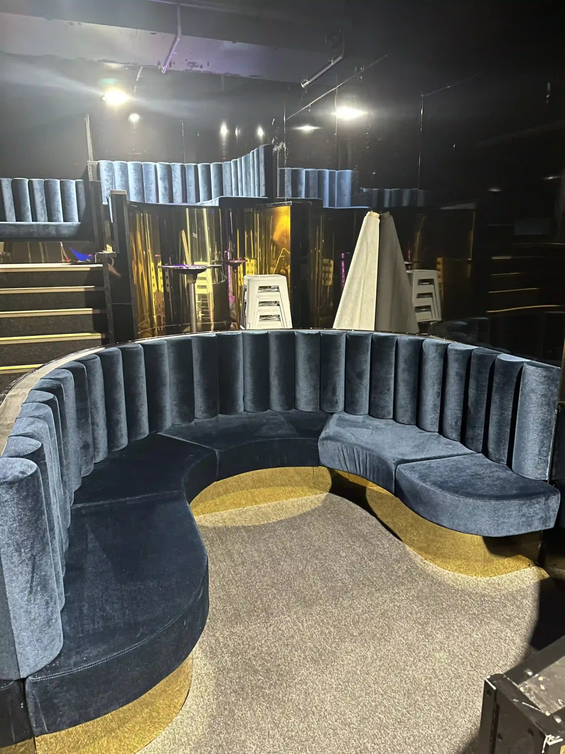 A completed bar fit out with a curved banquette and feature lighting