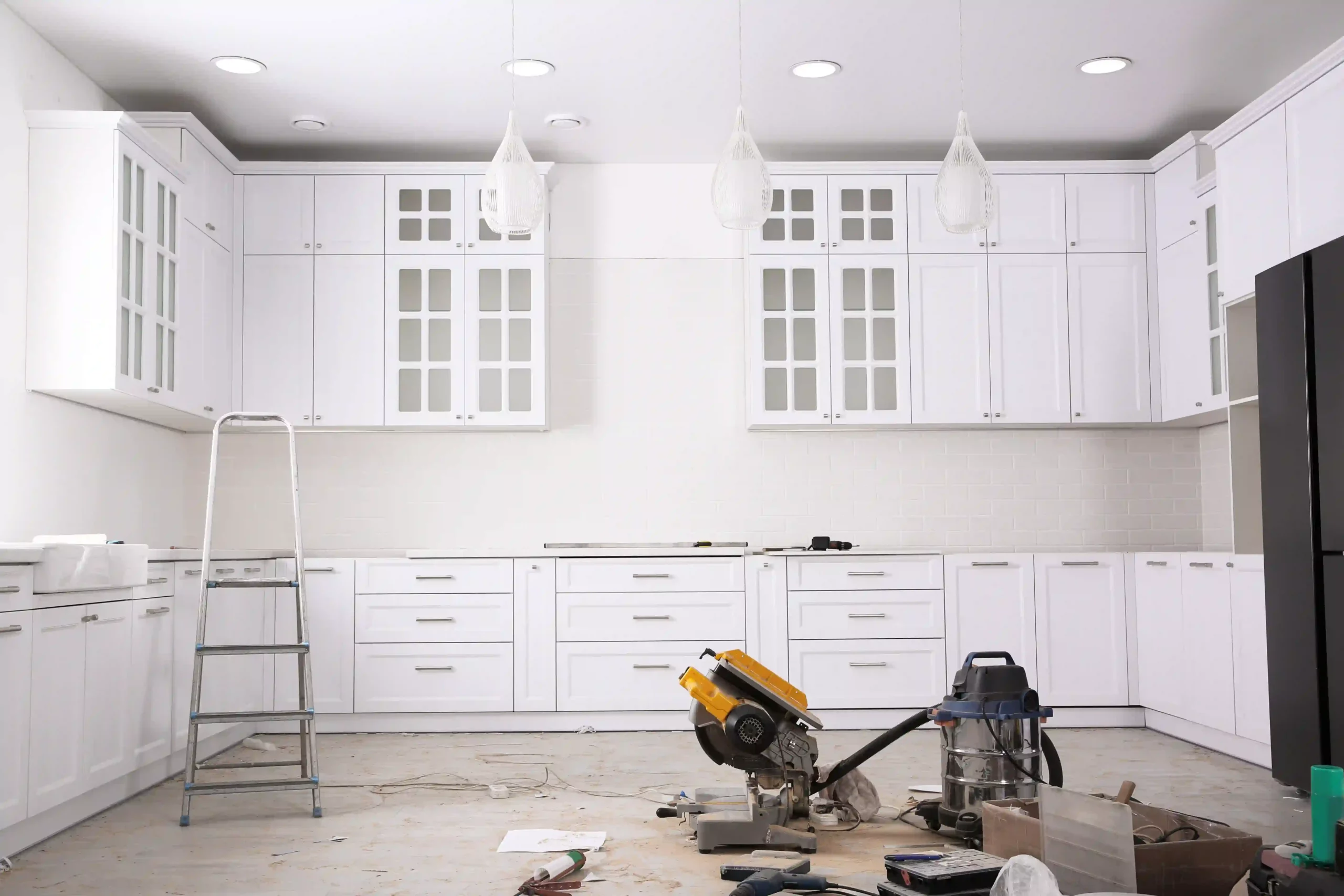 White cabinetry and pendant lighting in a modern kitchen under renovation, a style that JL Coastal Projects can deliver for Gold Coast homeowners.